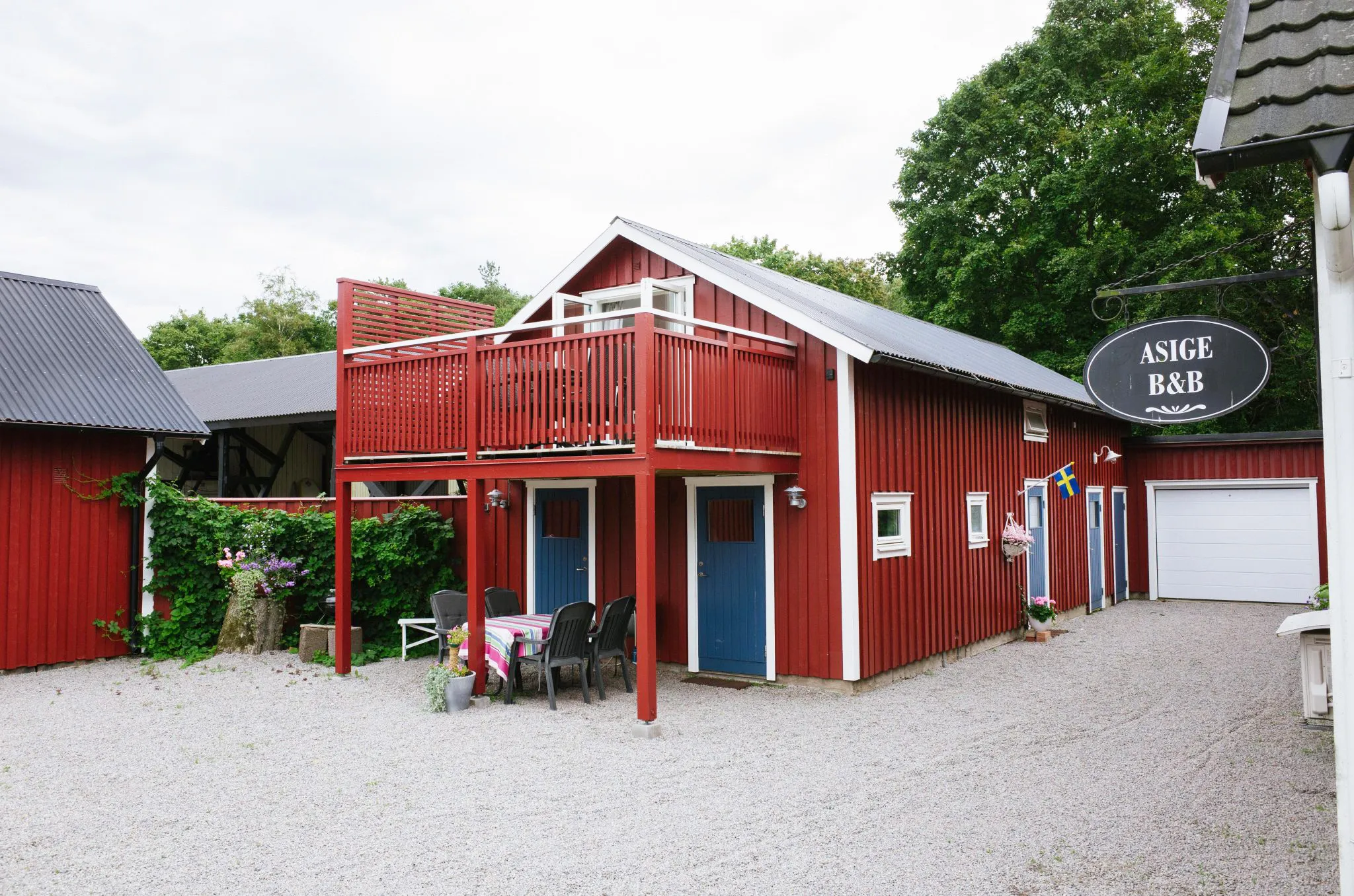 Röd byggnad på grusplan.