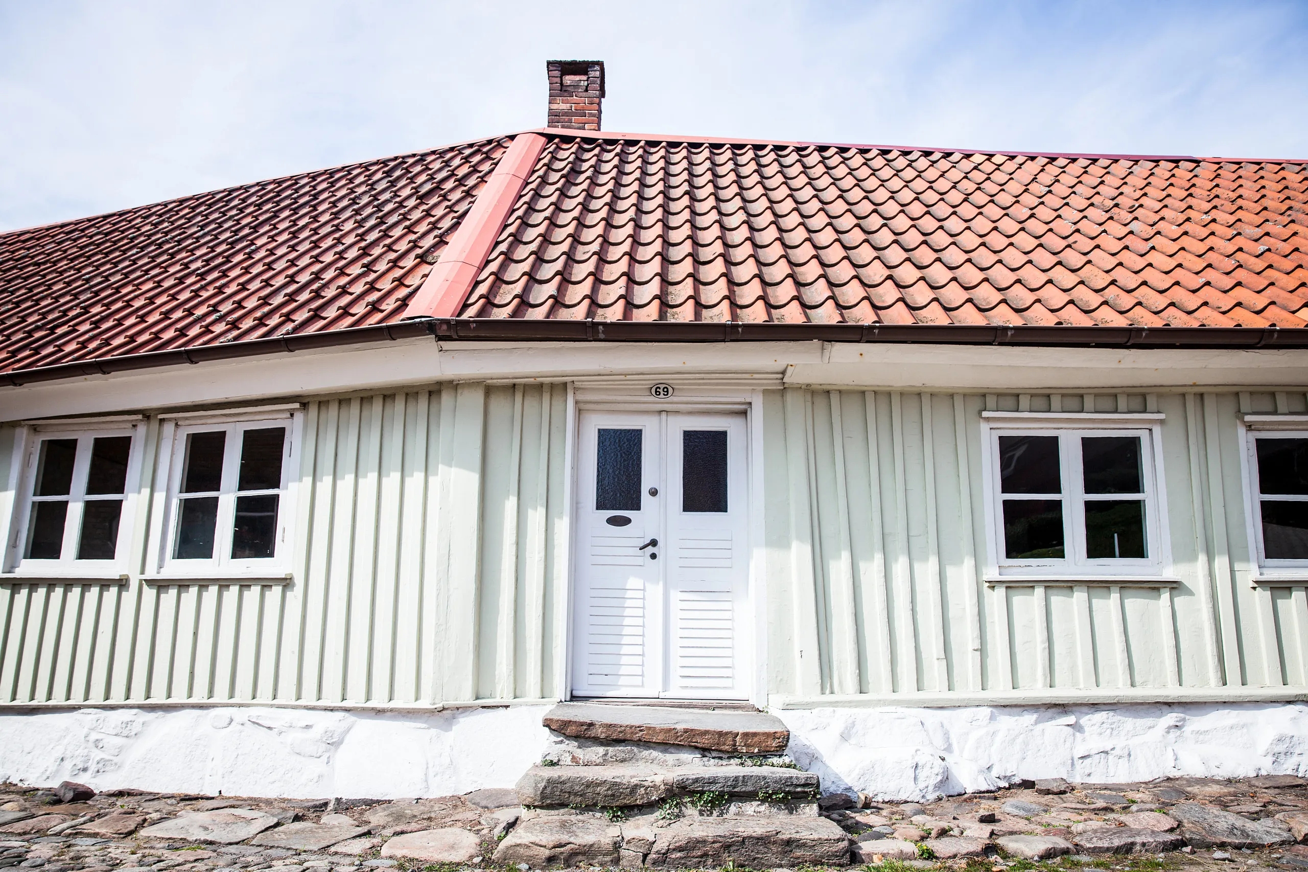 Grönt trähus med vit dörr