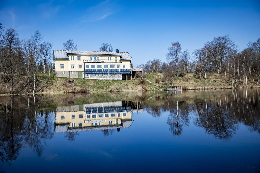 Gul byggnad framför sjö.