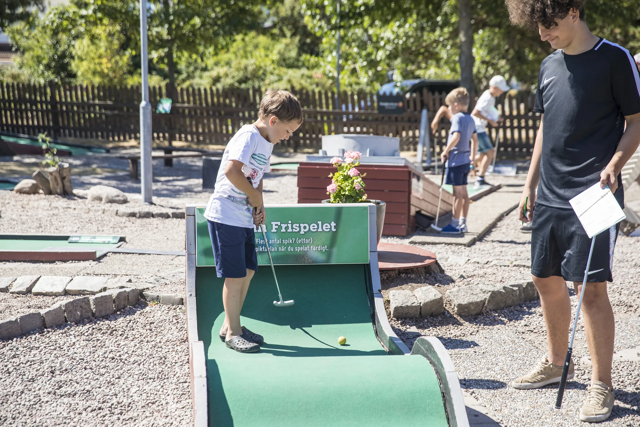 Killar som spelar minigolf tillsammans på Skea