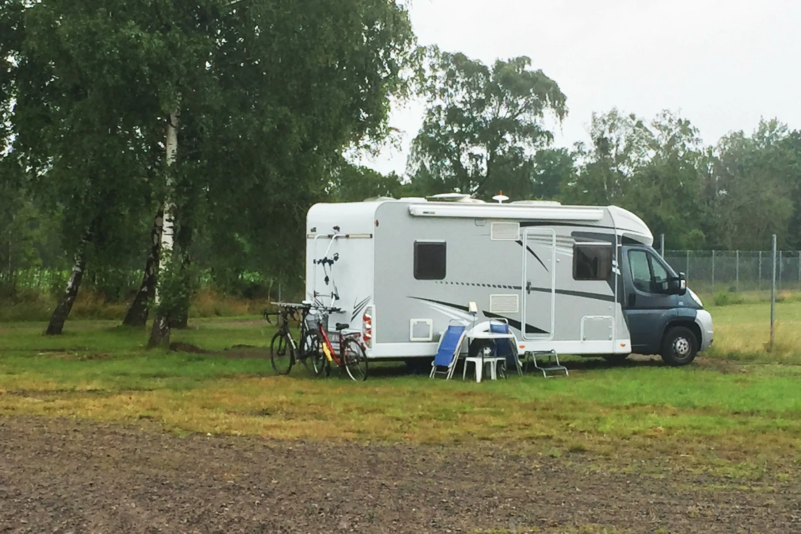 En husbil parkerad på gräsplätt.