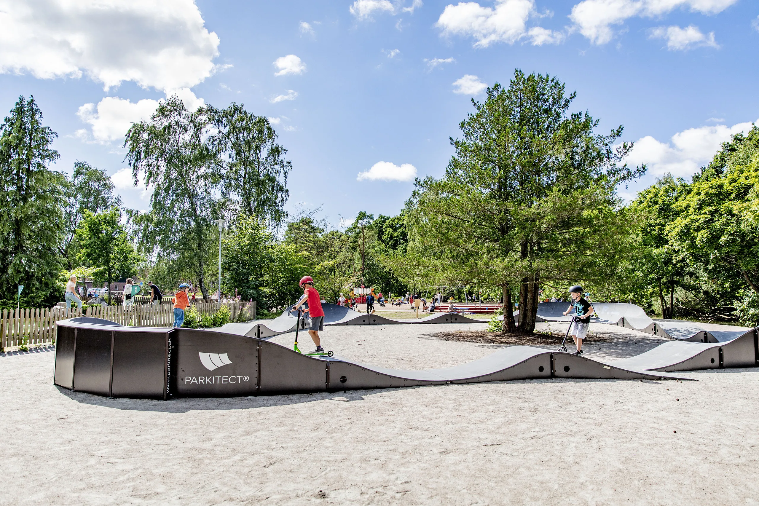 Barn som åker kickbike på pumptrack-banan