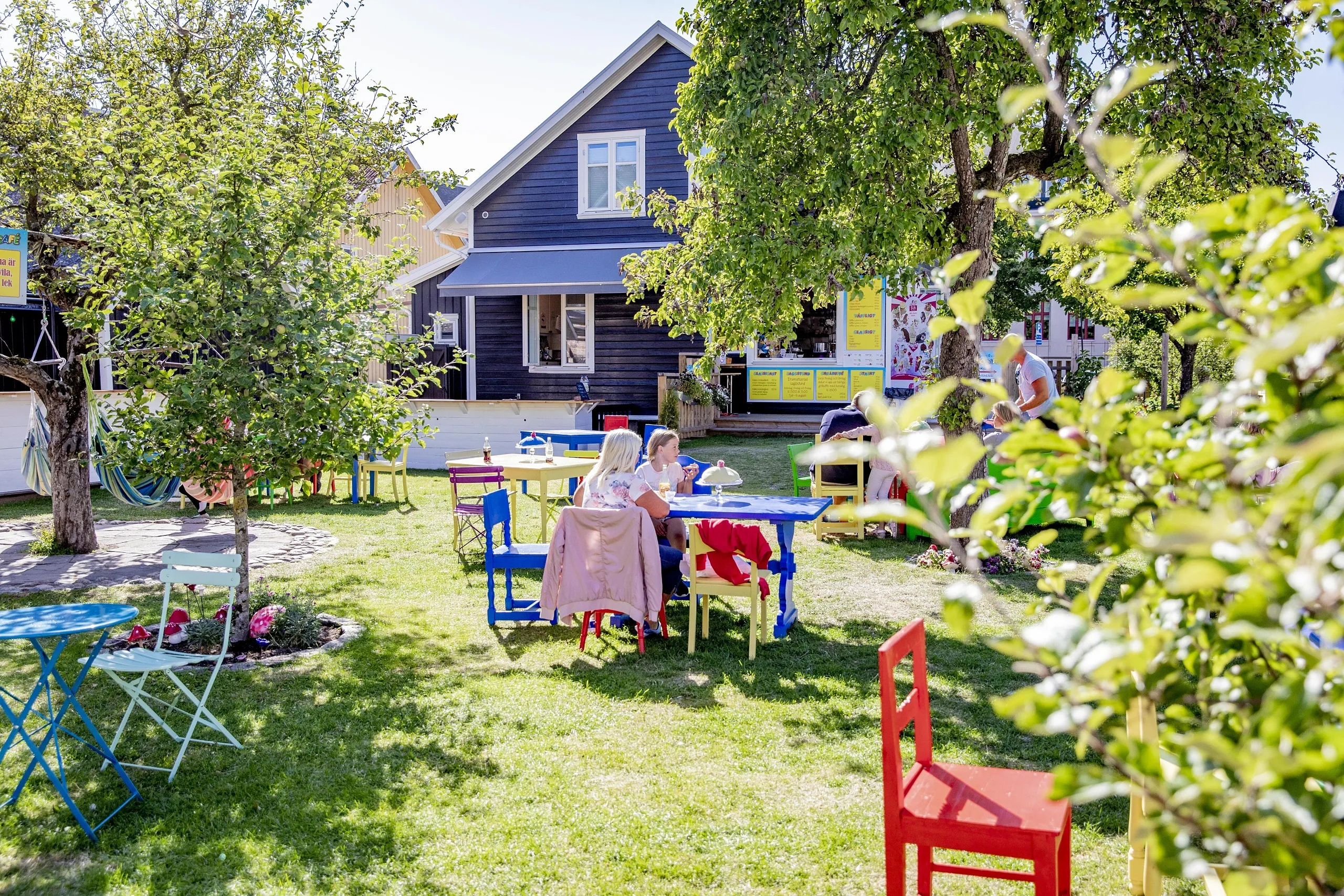Trädgårdscafé med färglada möbler