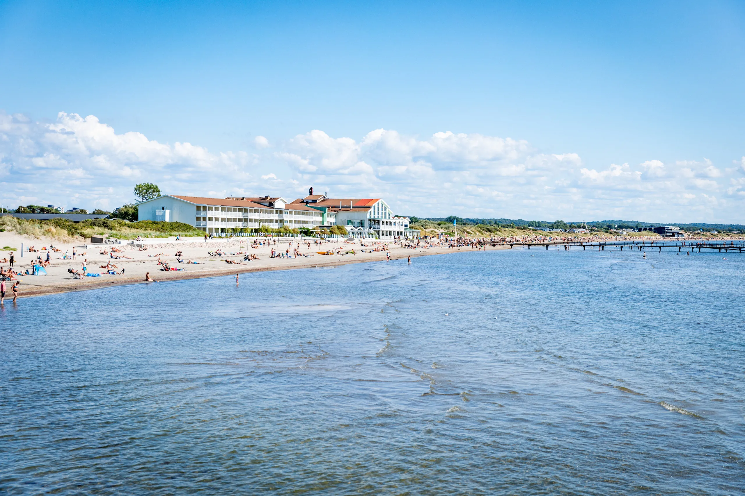Vy över Skrea strand med stort vitt hotell mitt på standen.
