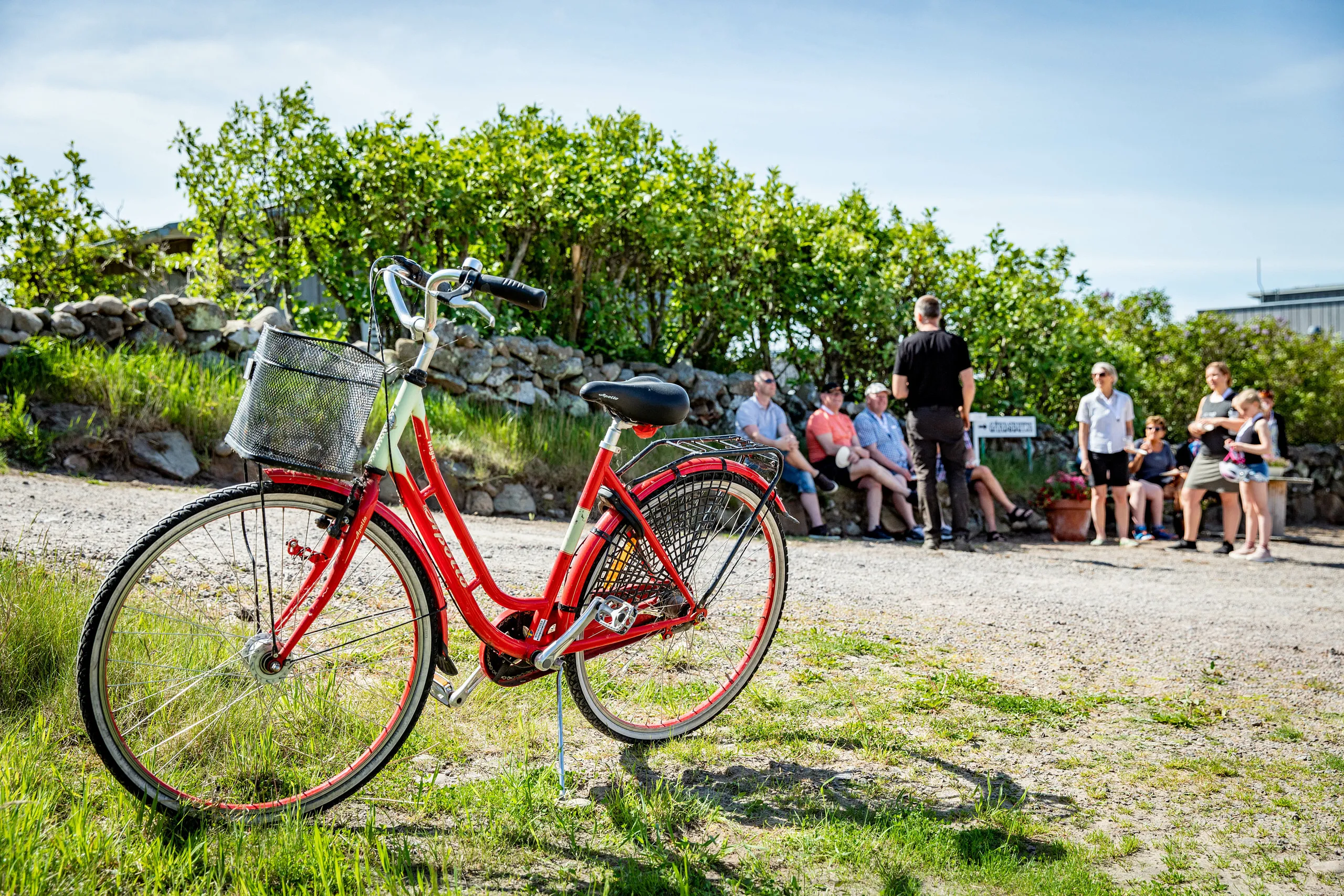 Cykel, i bakgrunden en grupp som får guidning.