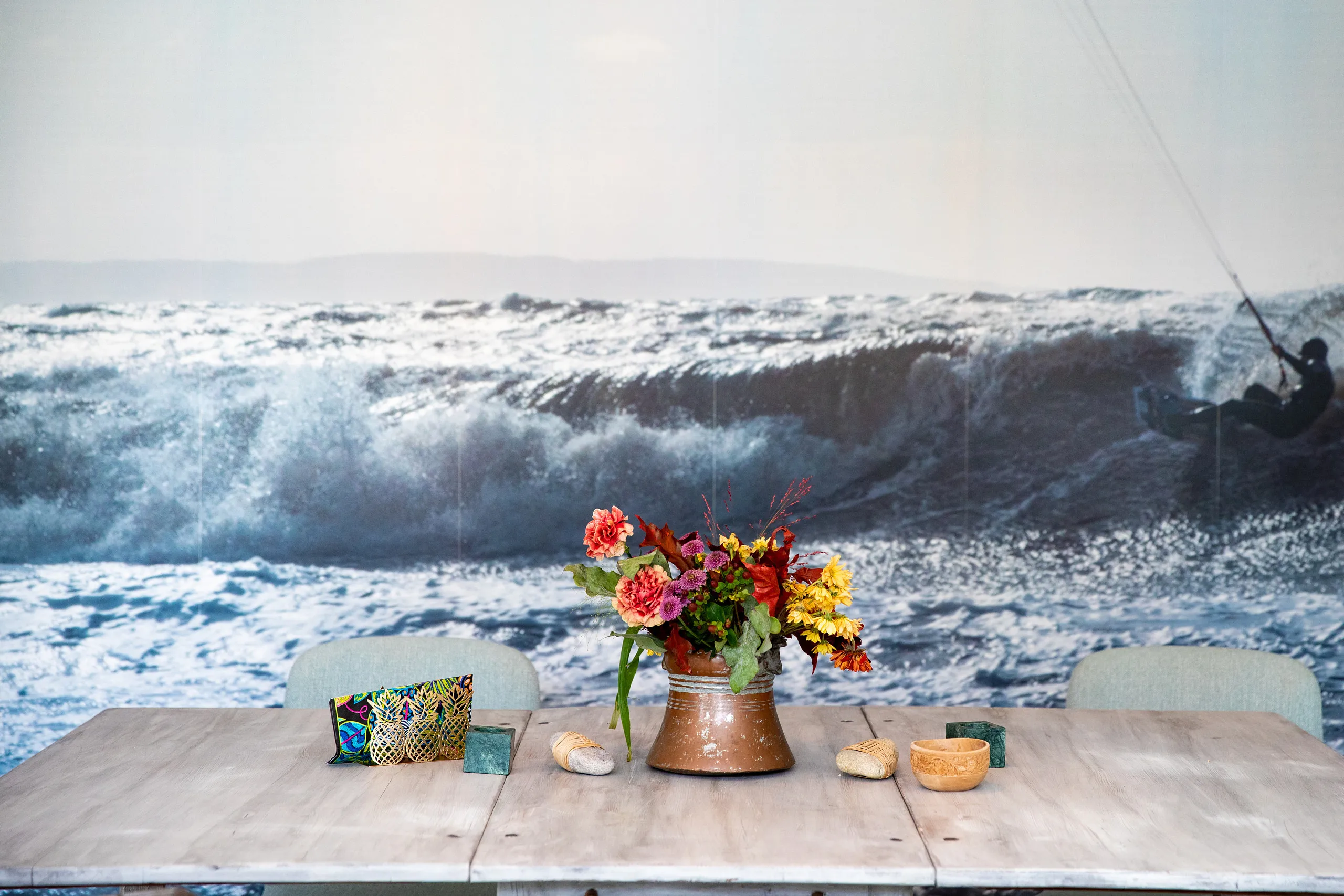 Bord med blommor, i bakgrunden en fototapet med vågor på.