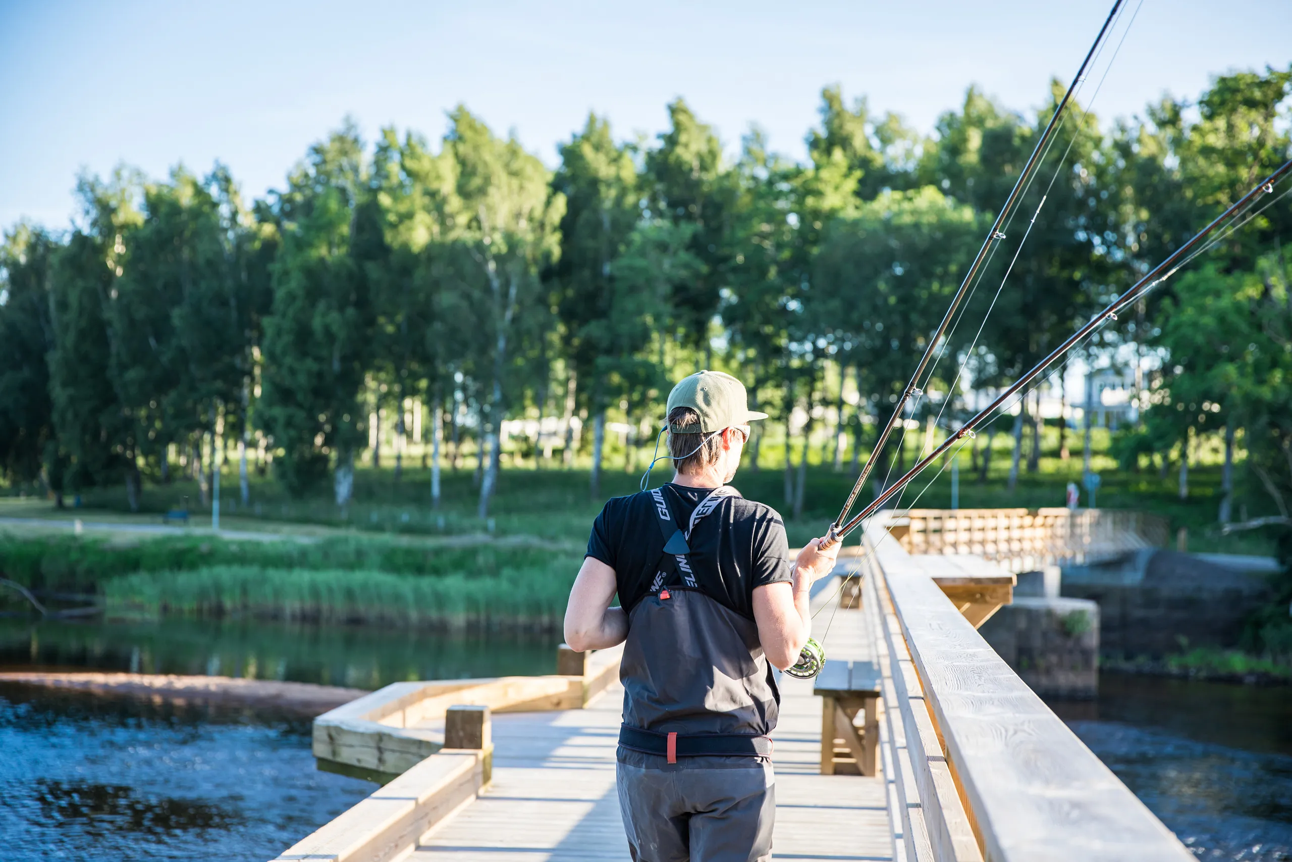 Fiskare som står på träbron vid namn laxbron