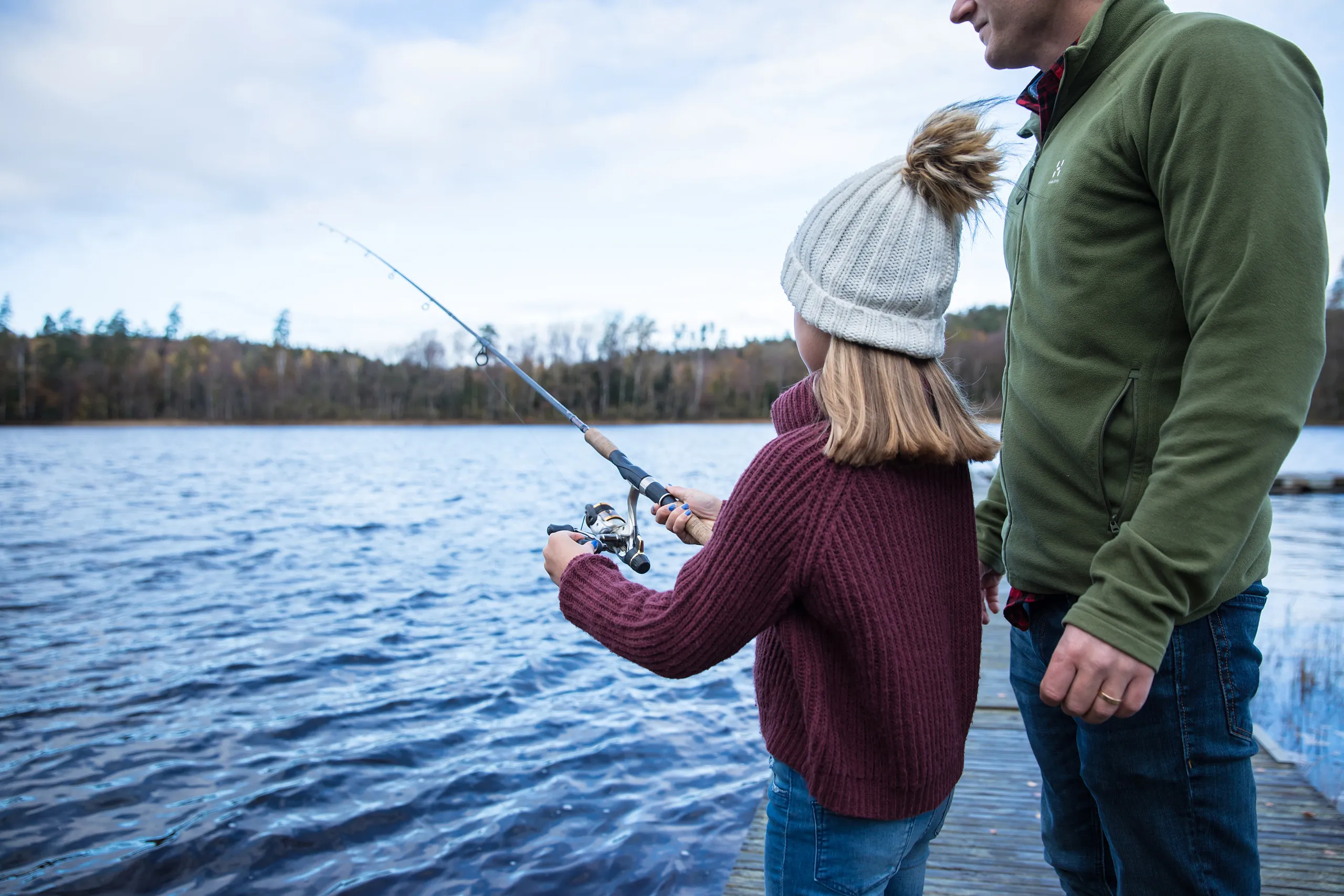 En man och en flicka som fiskar i en sjö