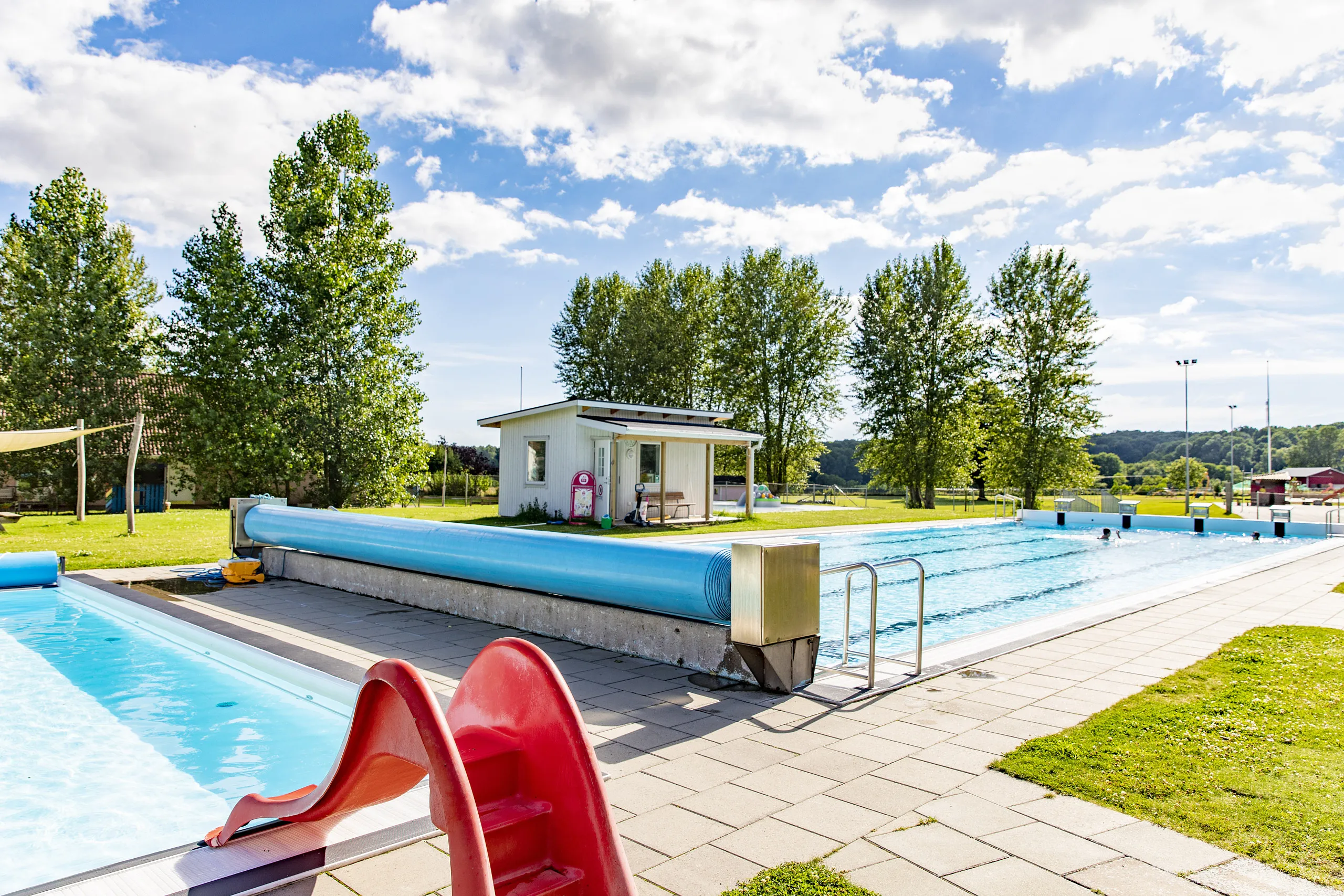 Utomhus badanläggning med en röd rutschbana