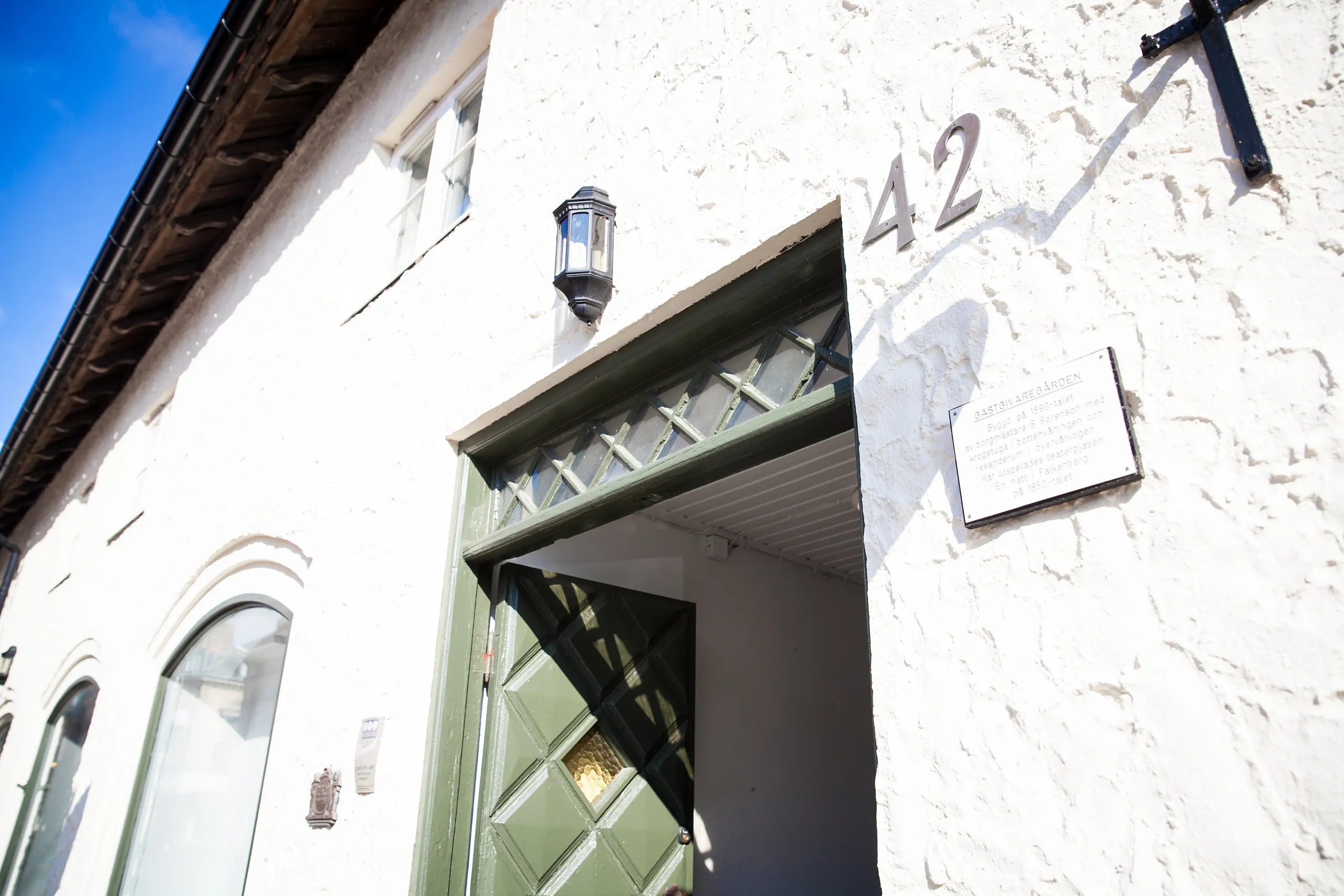 Grön dörröppning på ett hus med vit fasad