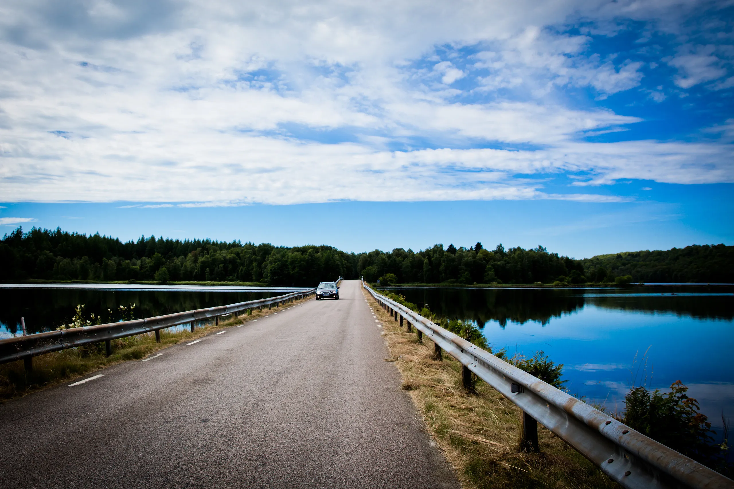Bil som åker över en bro vid en sjö