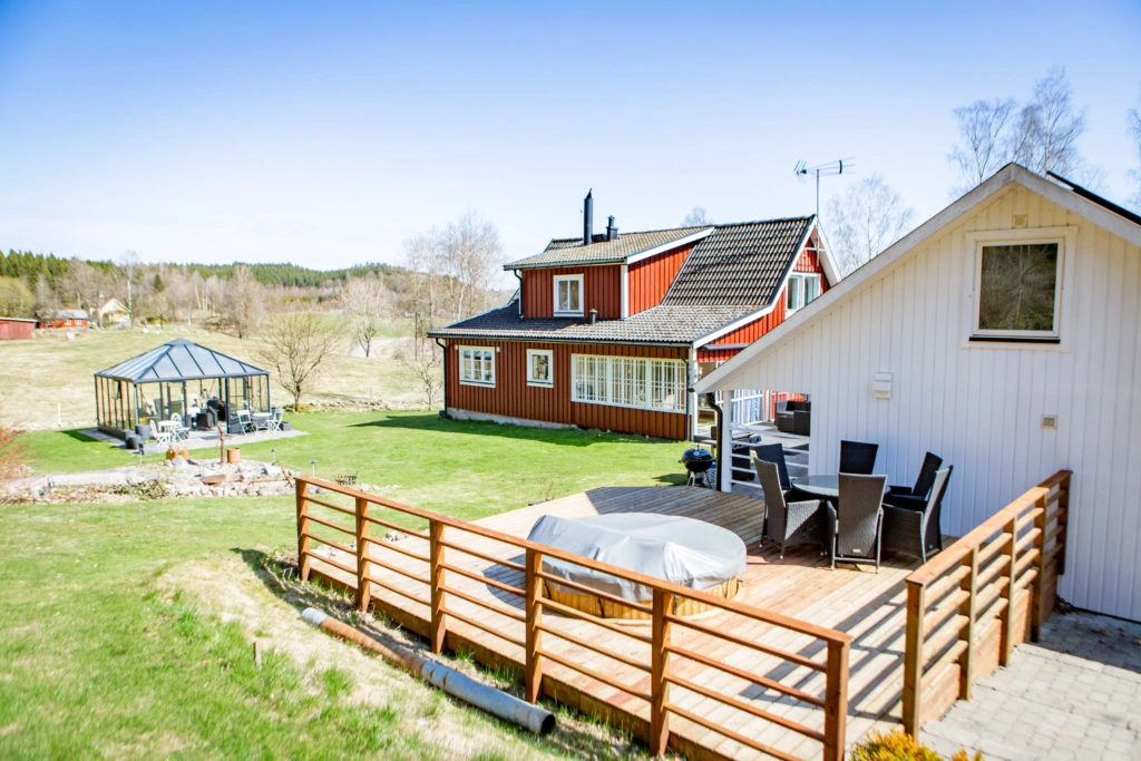 Ett vitt och ett rött hus, en trädgård med växthus.