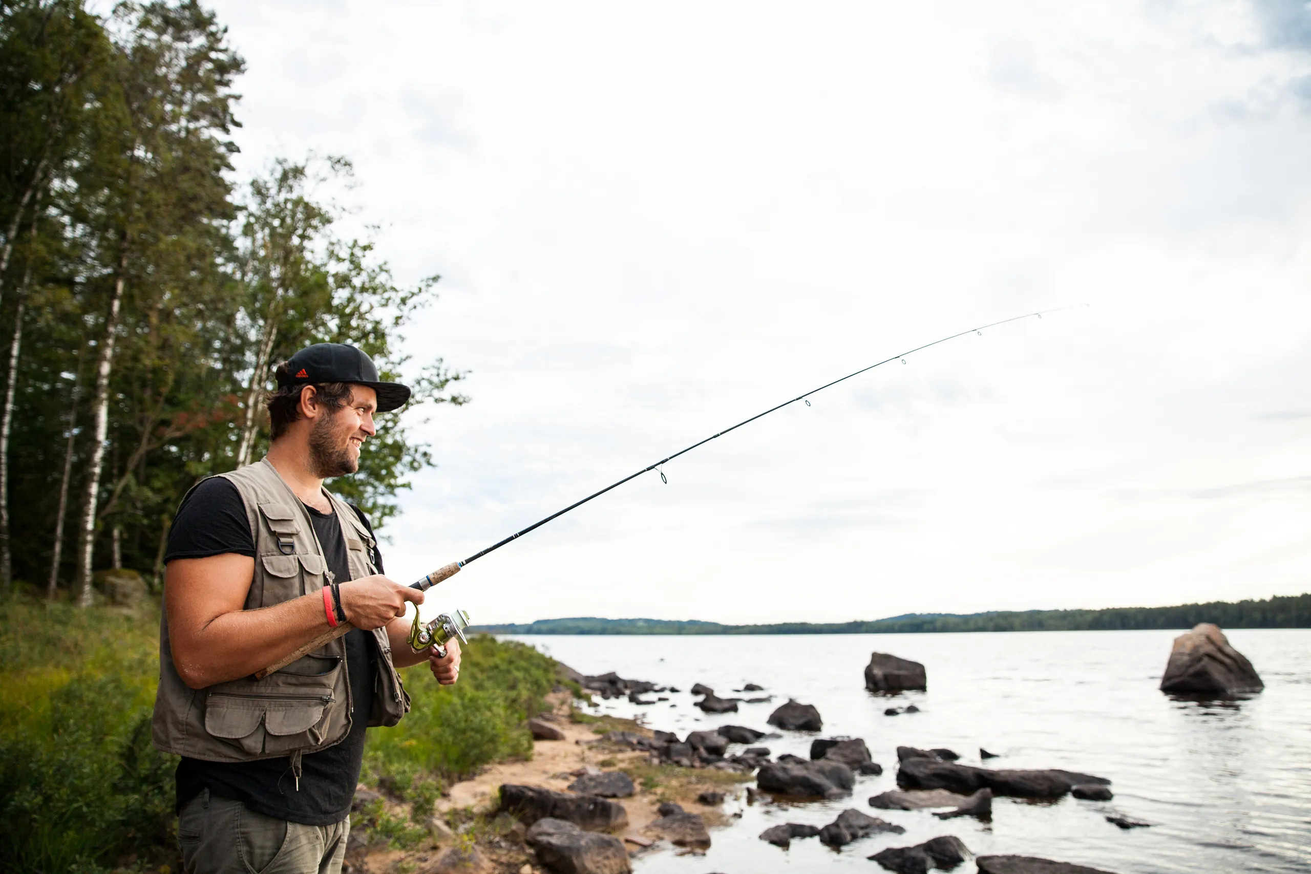 person med fiskespö vid en sjö i en skog