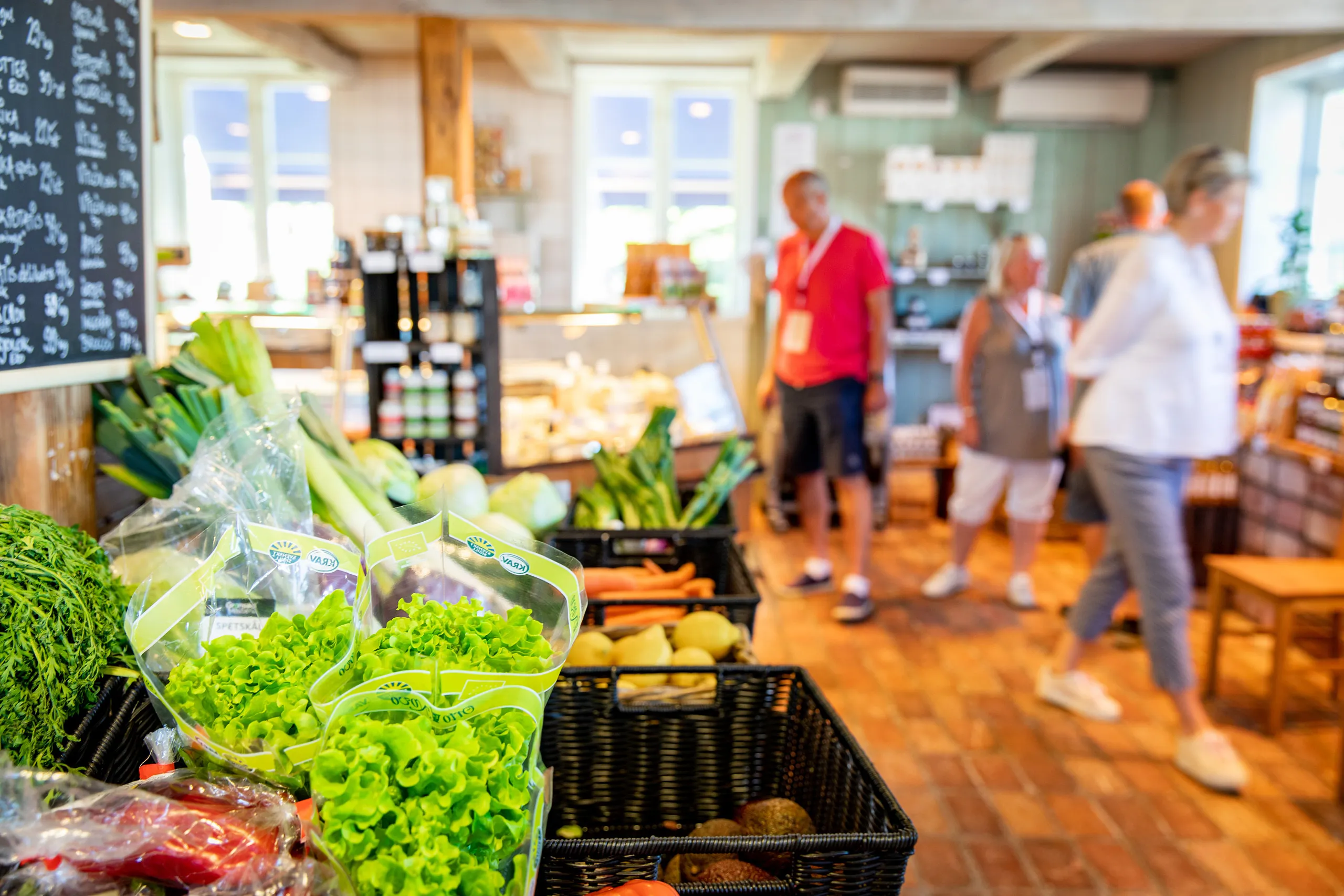 Grönsaker och personer i en gårdsbutik