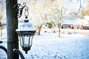 Lantlig lykta mot stolpe i vinterlandskap