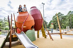 barn klättrar i tunnor på lekplats