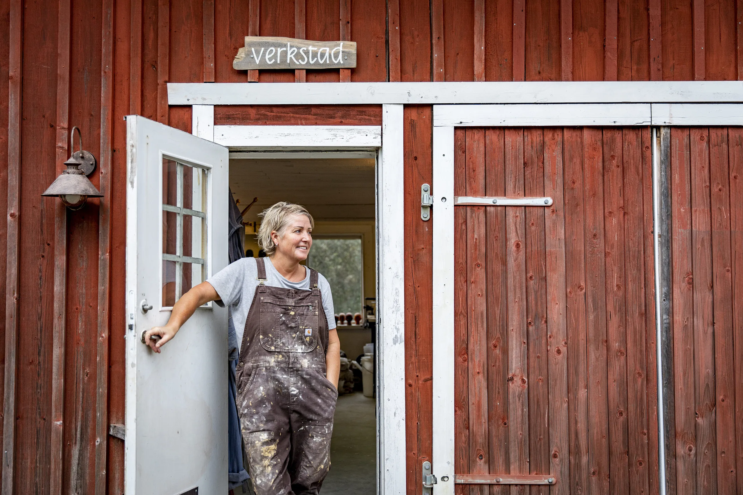 Kvinna i dörröppning till sin keramikverkstad.