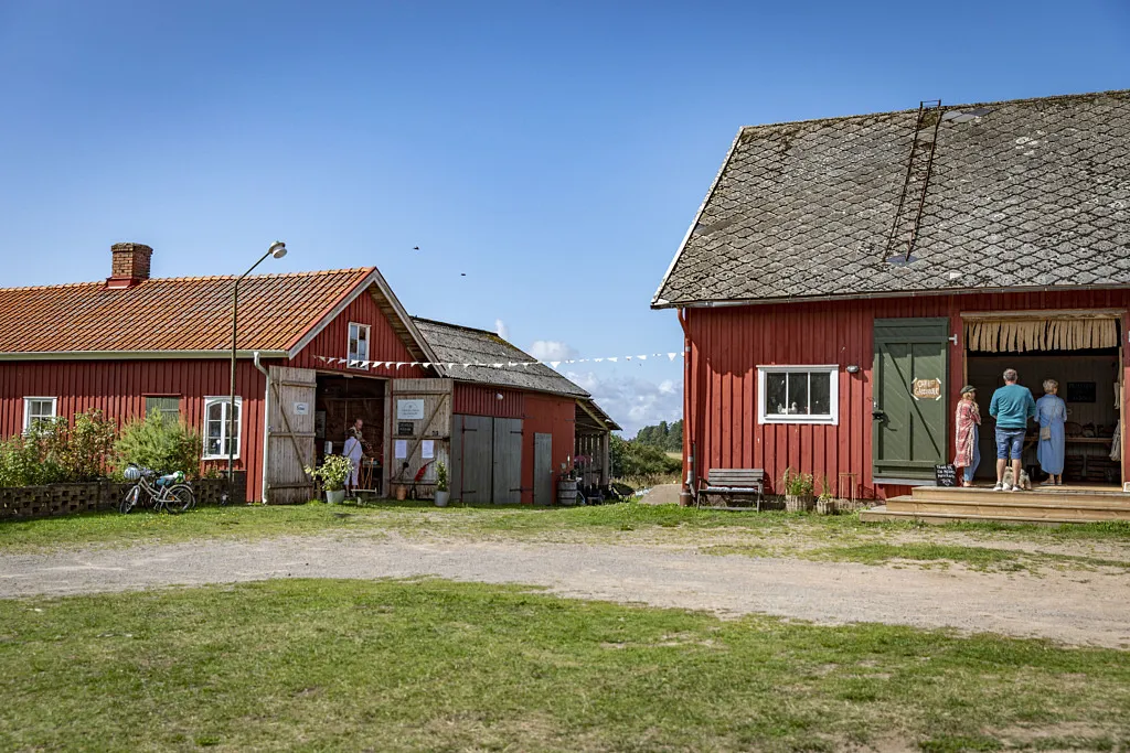 Gårdsmiljö med röd ladugård.