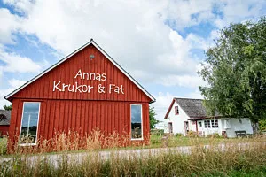 rött hus med texten annas krukor och fat på gaveln