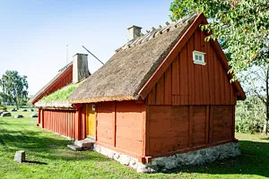 Röd gammal stuga med halmtak