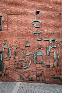 kopparkonstverk på tegelvägg