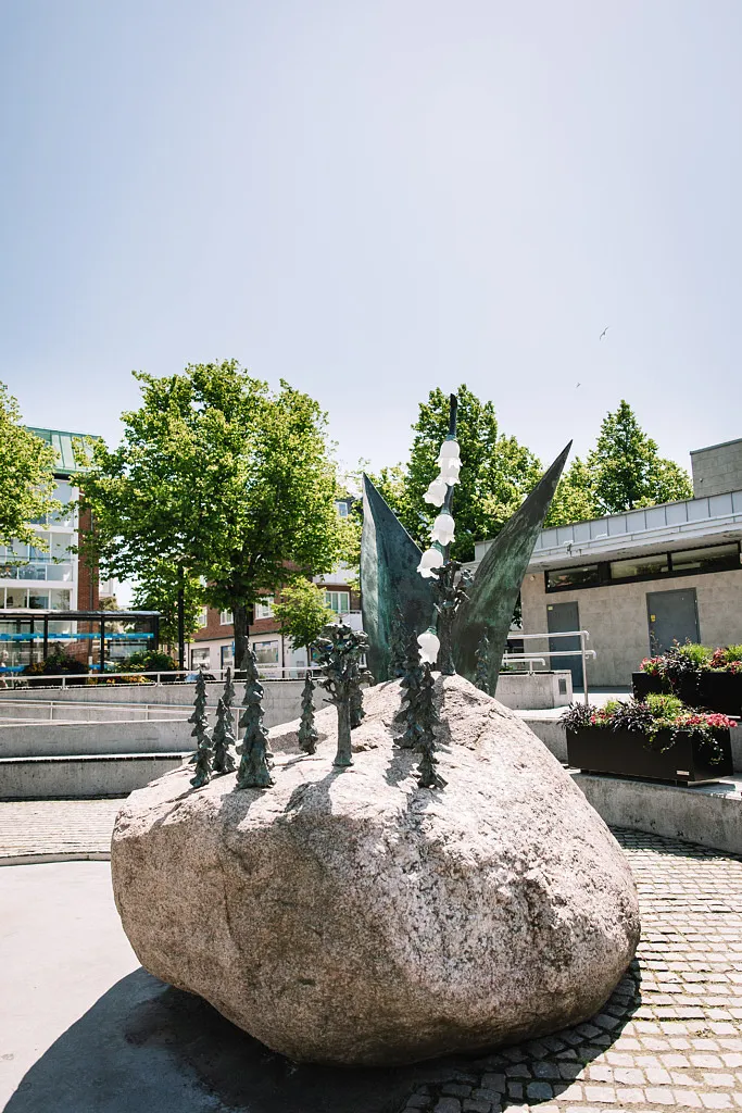 sten med bronsskulptur föreställande blommor
