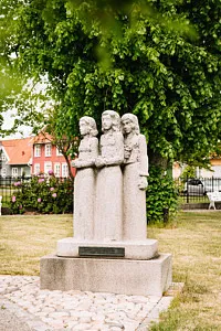 stenskulptur av tre flickor