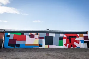 muralmålning på lång vägg under blå himmel