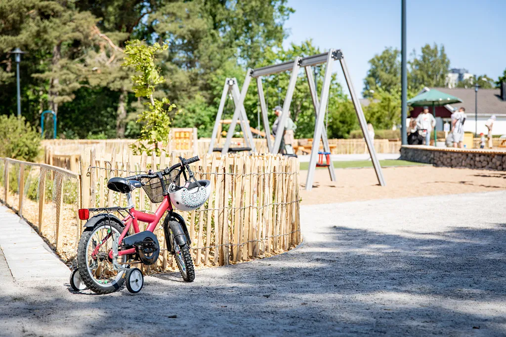 Cykel med stödhjul parkerad på lekplats