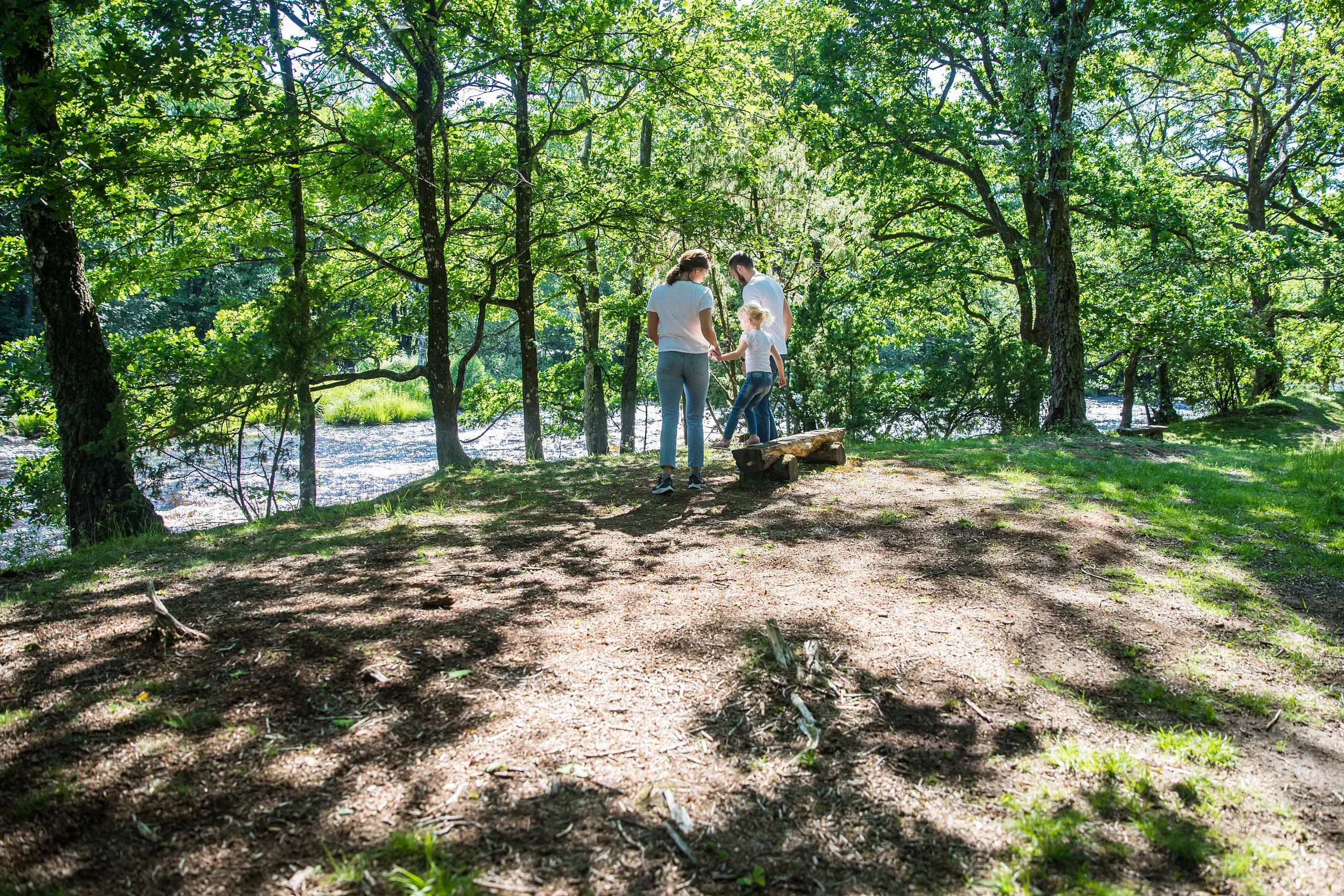 familj i skogsglänta vid vatten