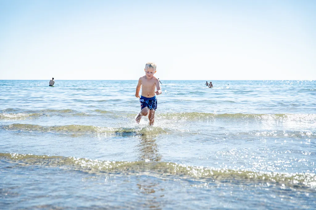 Pojke som springer i vattnet.
