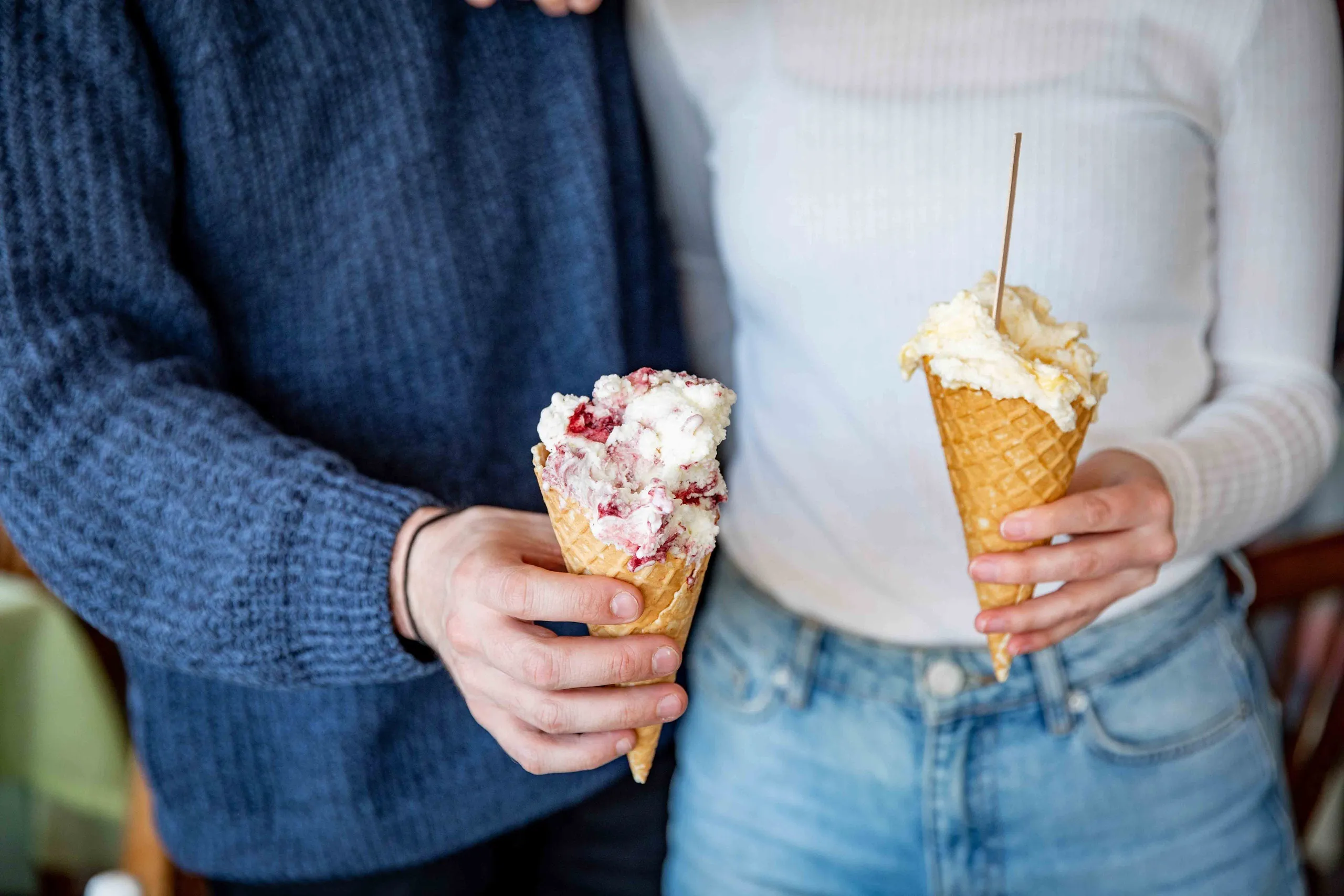 två personer håller varsin strut med glass