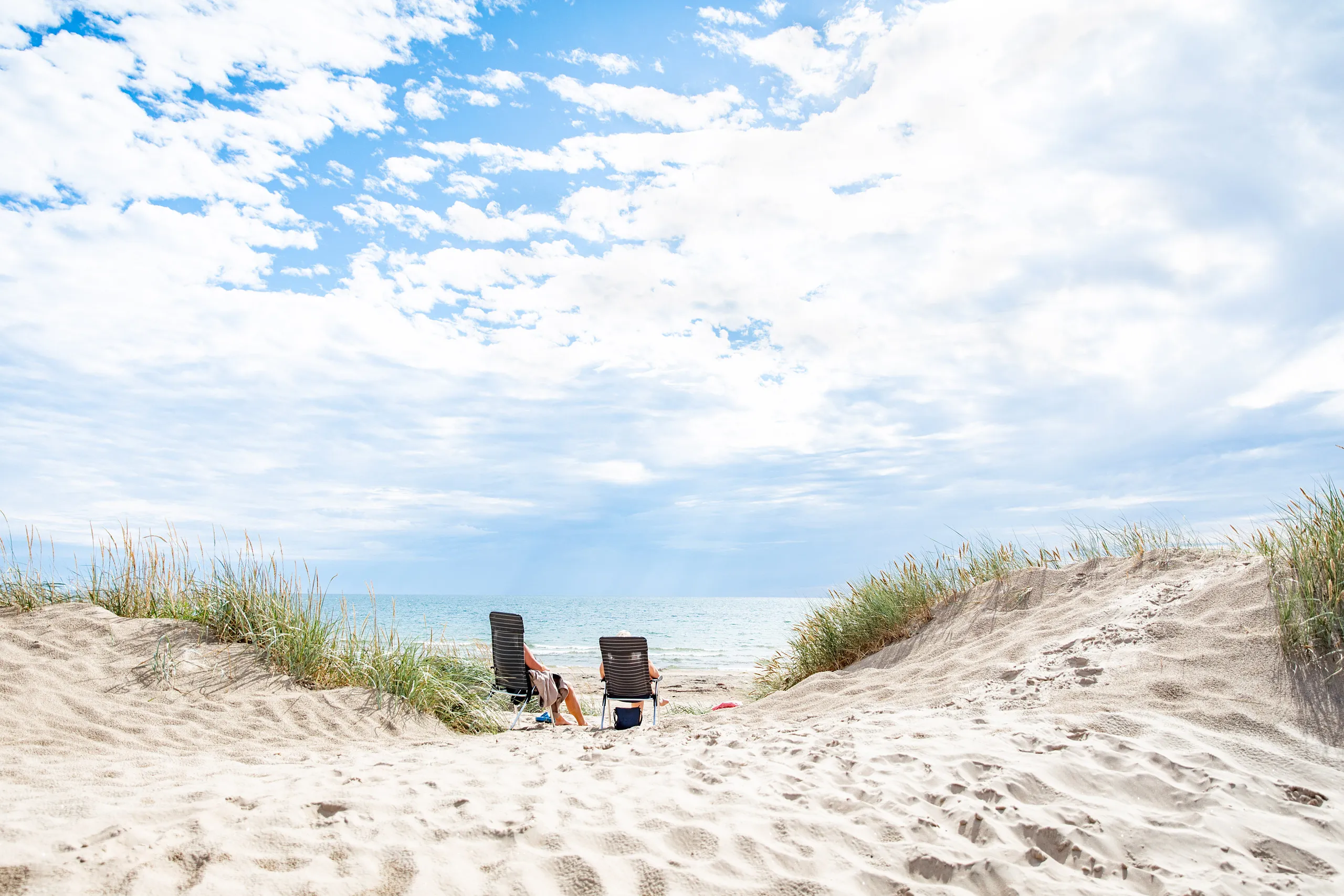 Två solstolar ensamma på stranden.