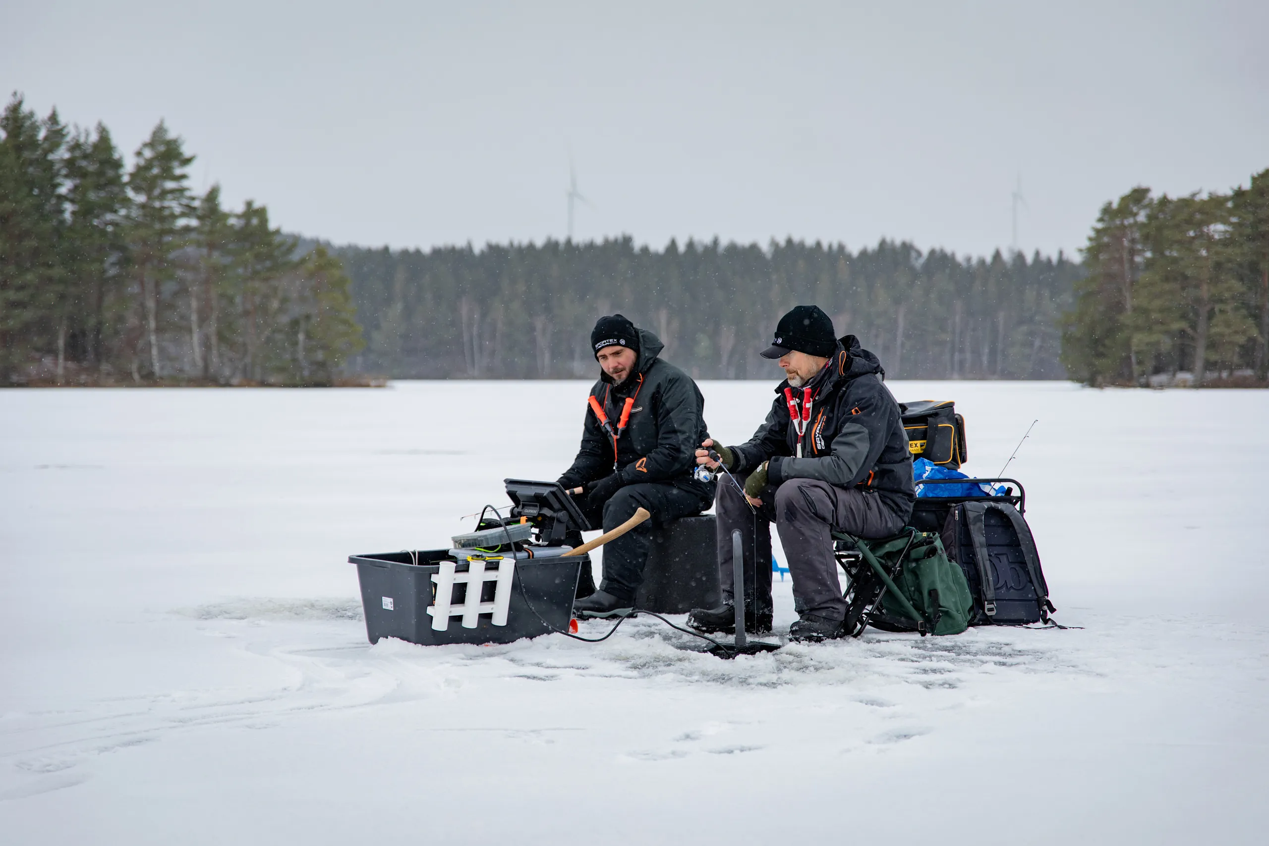 två fiskare isfiskar på sjö