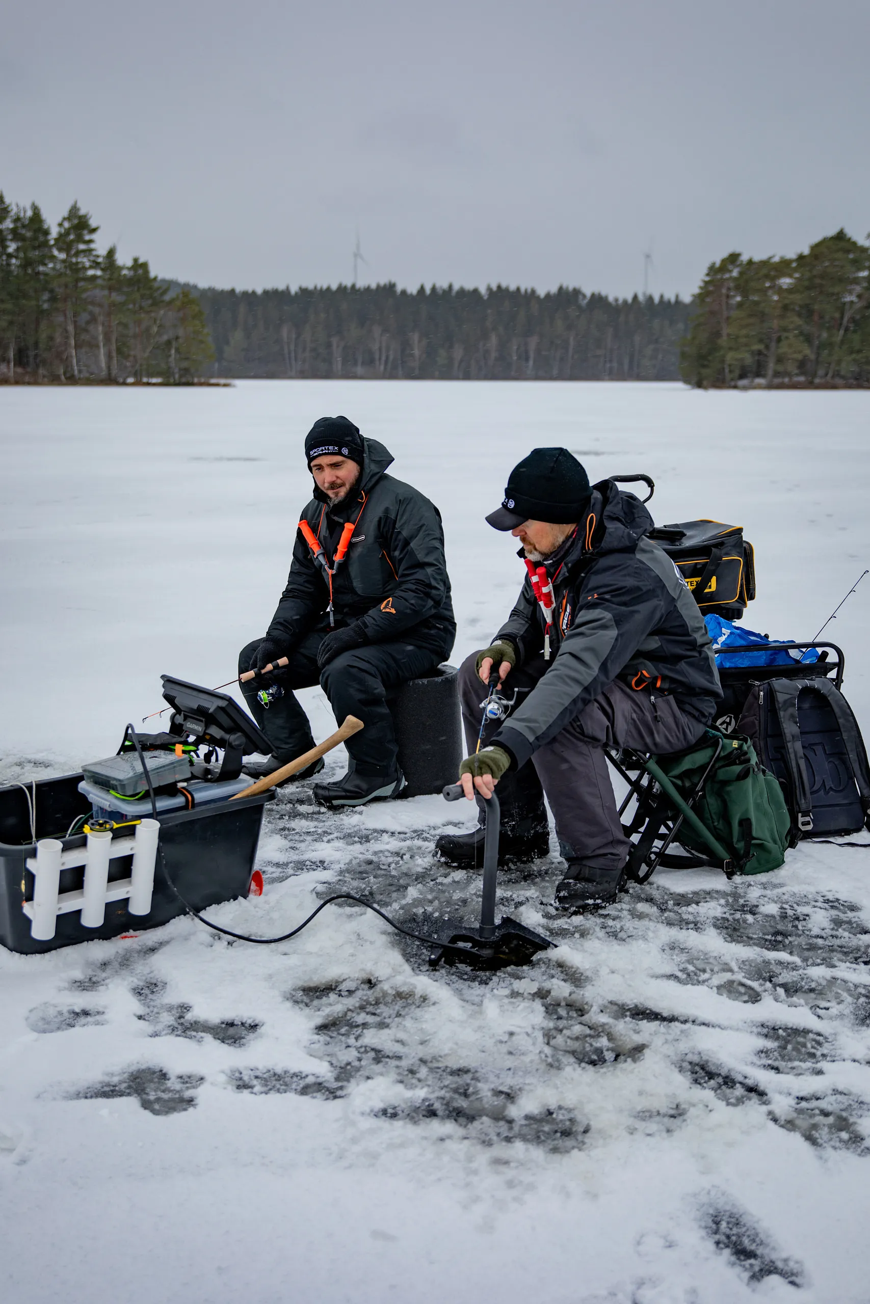 två fiskare isfiskar på sjö