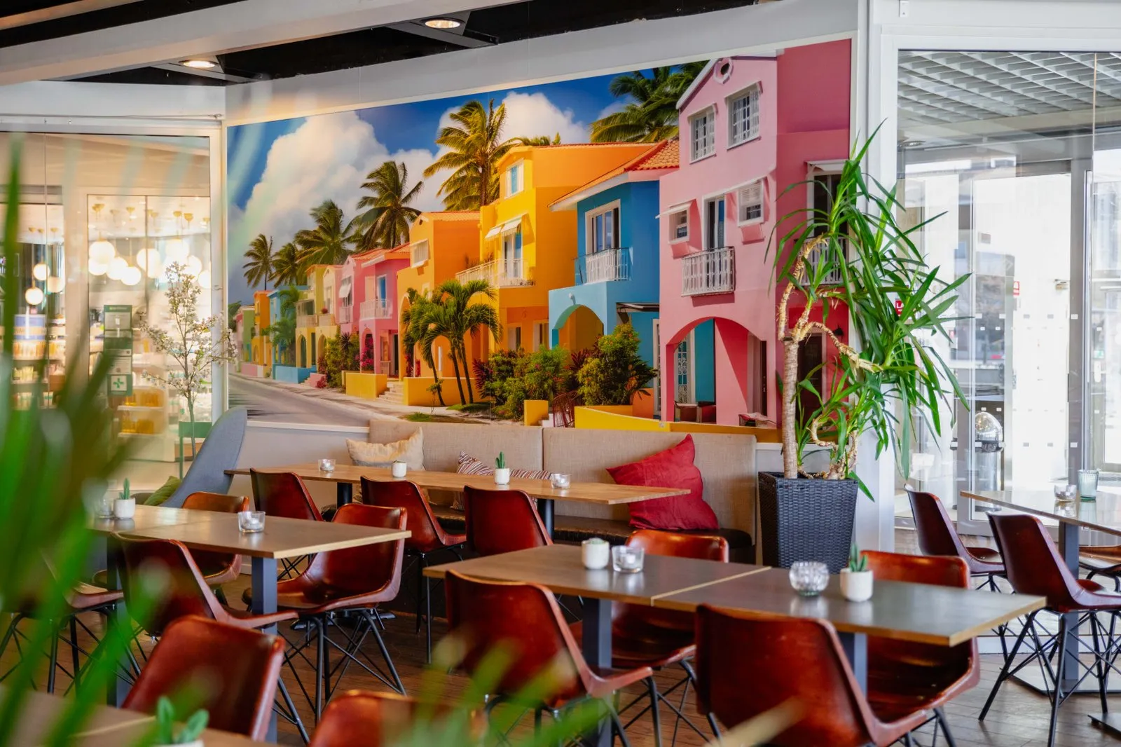 En restaurangmiljö med en väggmålning av färgglada hus.