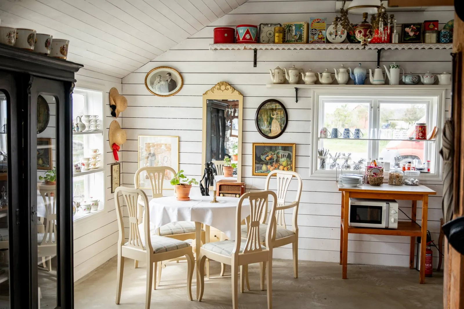 Miljö med gamal möbler och loppisföremål på hyllor.