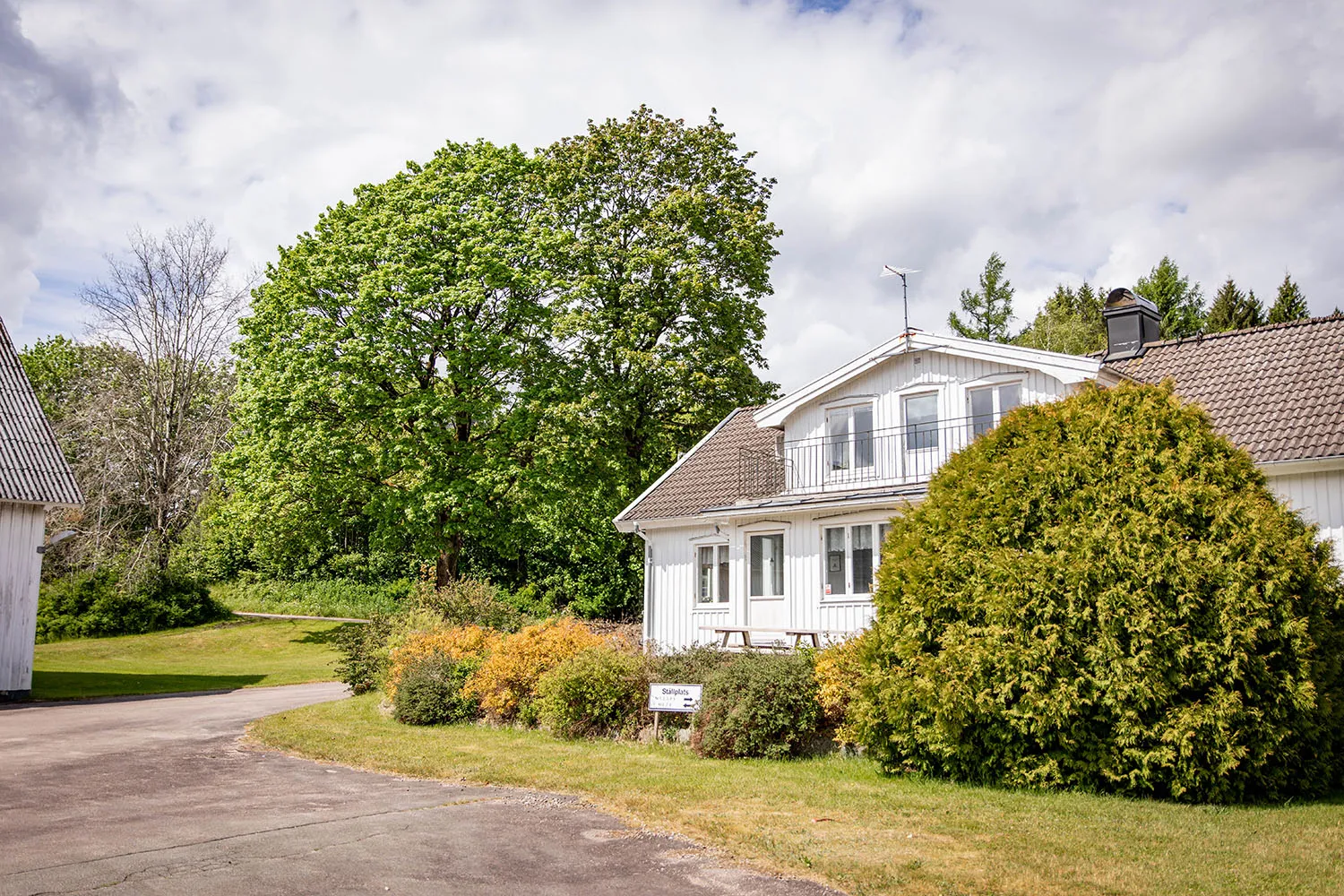 En vit villa inbäddad i grönska.