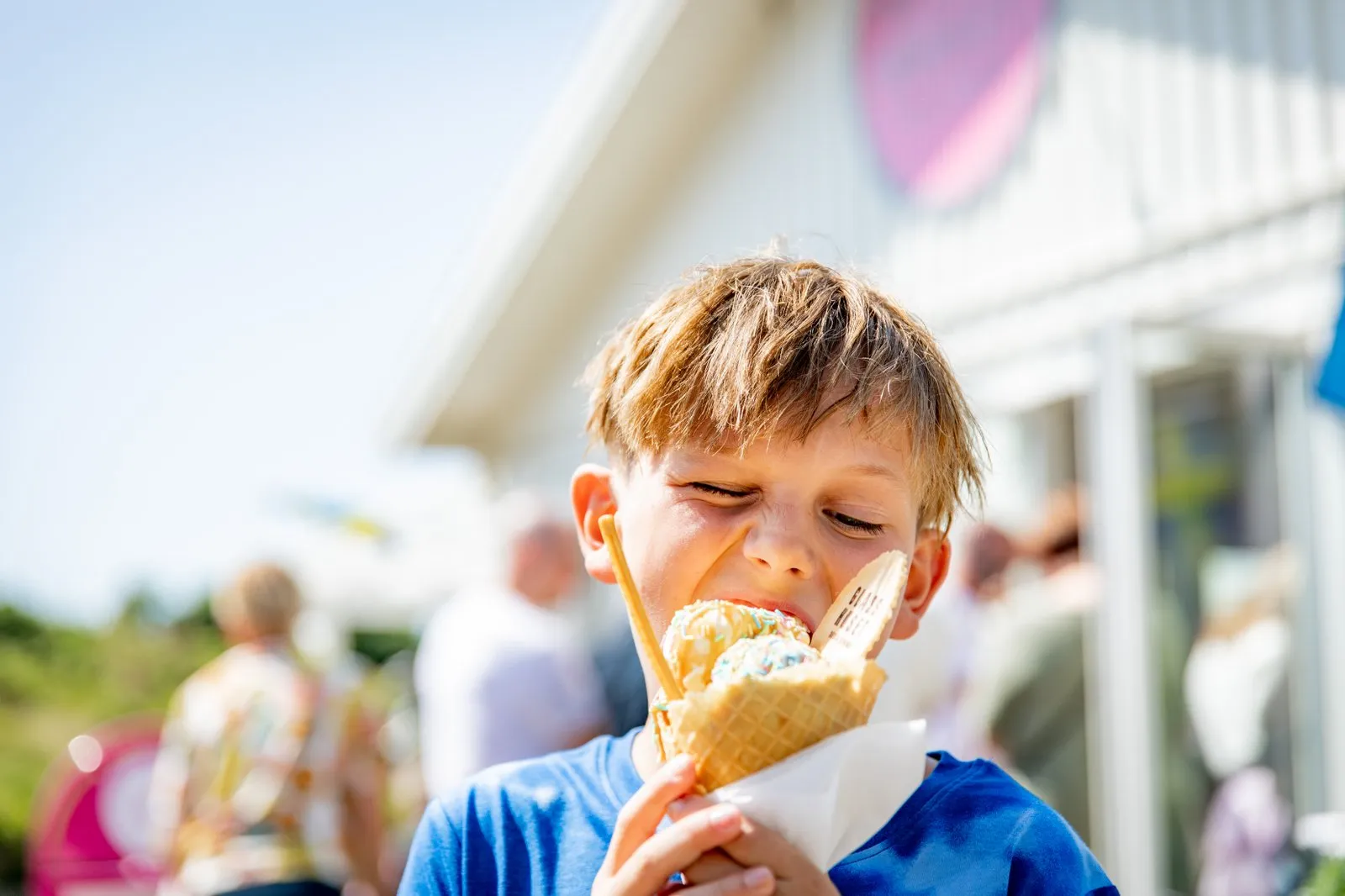 Pojke som äter en stor glasstrut.