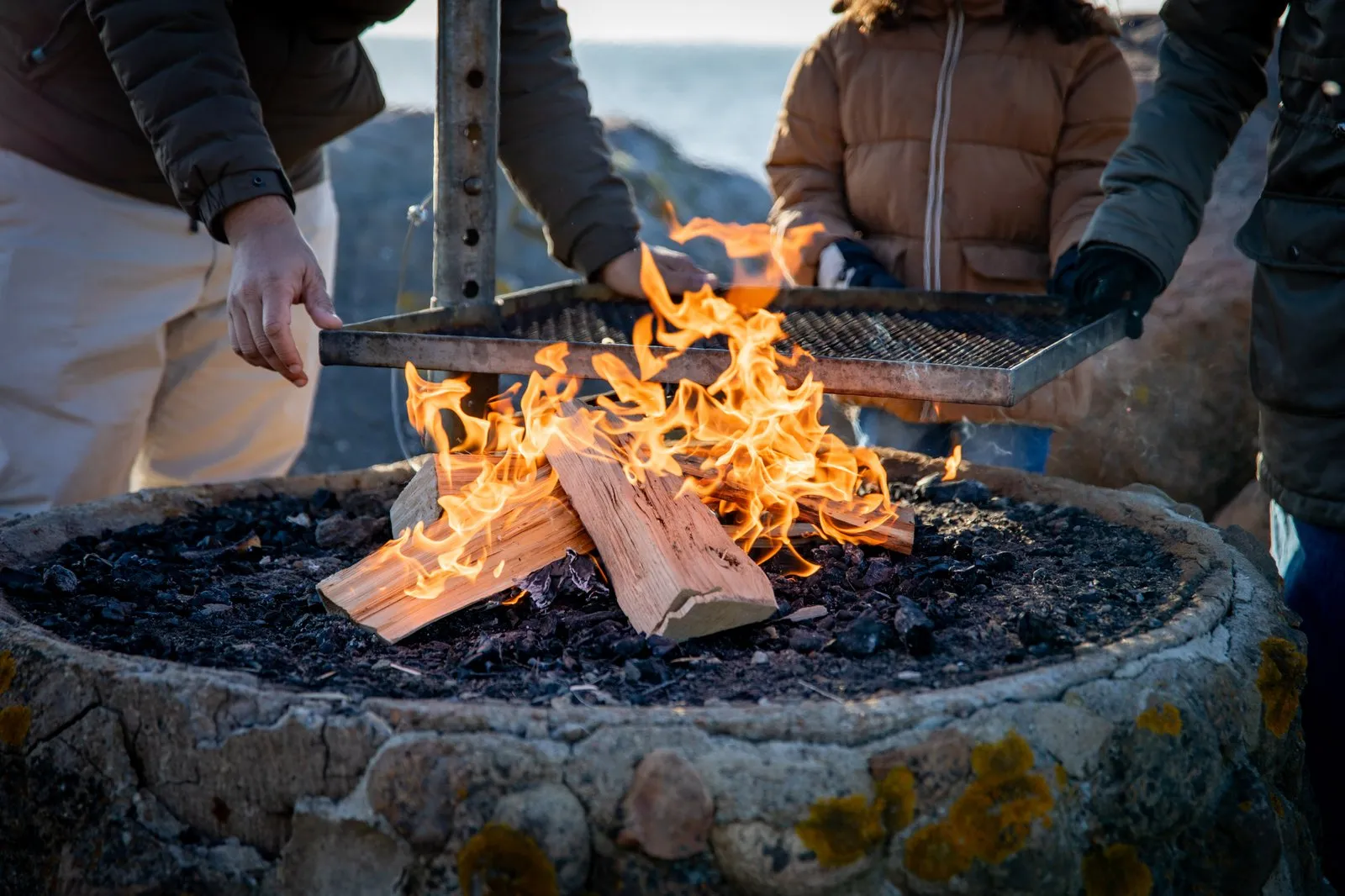 Några vedträn brinner på en grillplats utomhus