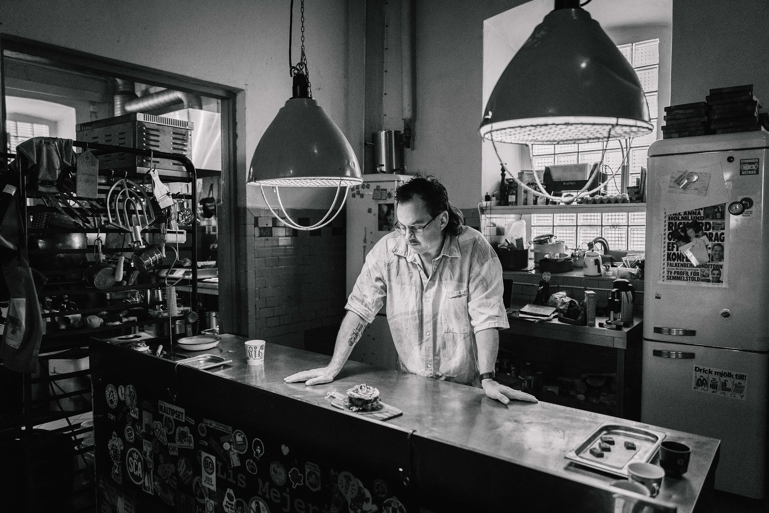 blidberg står vid en rostfri bänk med en macka