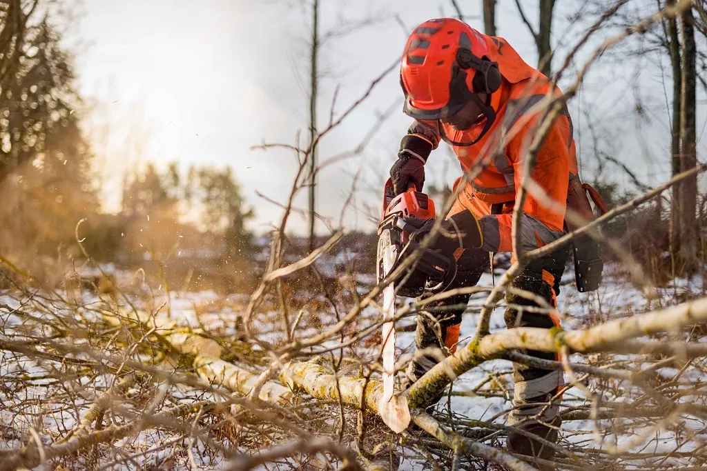 En person sågar motorsåg