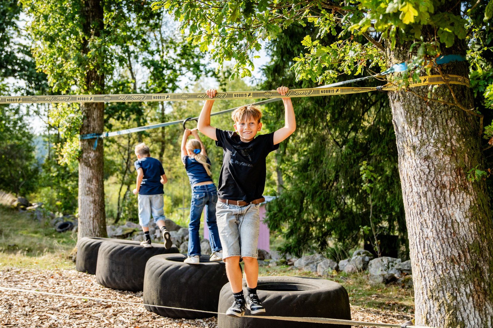 Barn som klättar på traktordäck och balanslinor.
