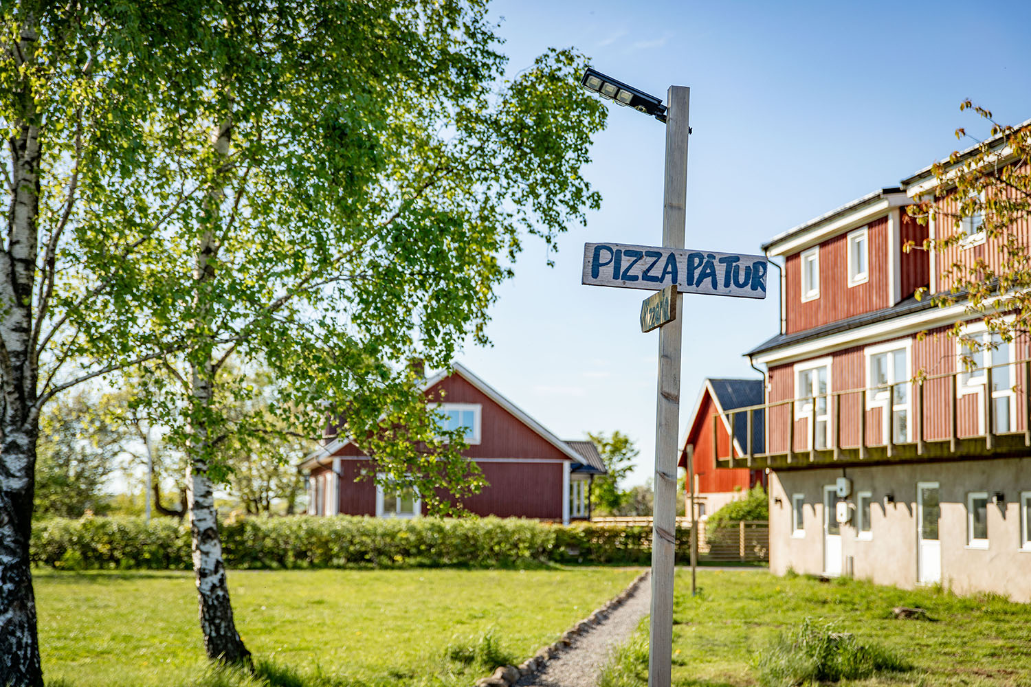En gårdsmiljö med en skylt "pizza på tur"