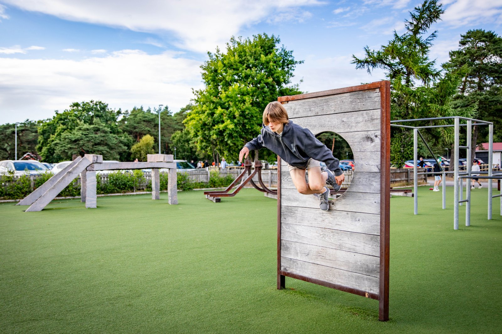 En ung kille hoppar igenom ett hinder på en parkourbana.