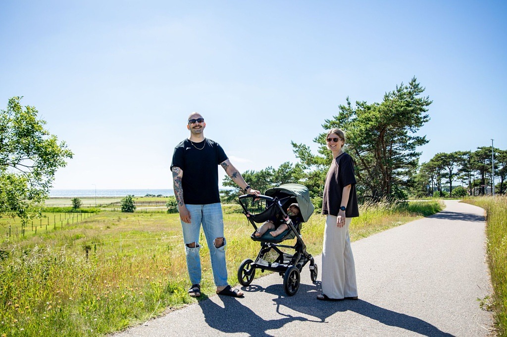 Ett par står med barnvagnen på en cykelväg mot havet.